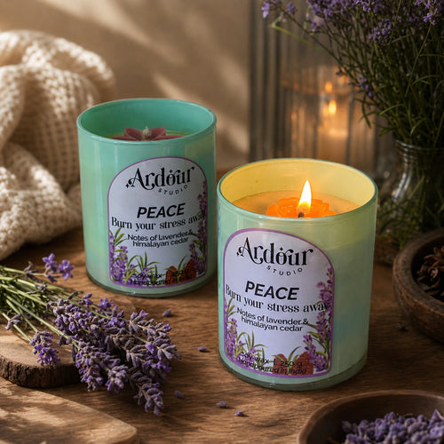 Two Acdour Studio 'Peace' candles with lavender flowers on a wooden surface.