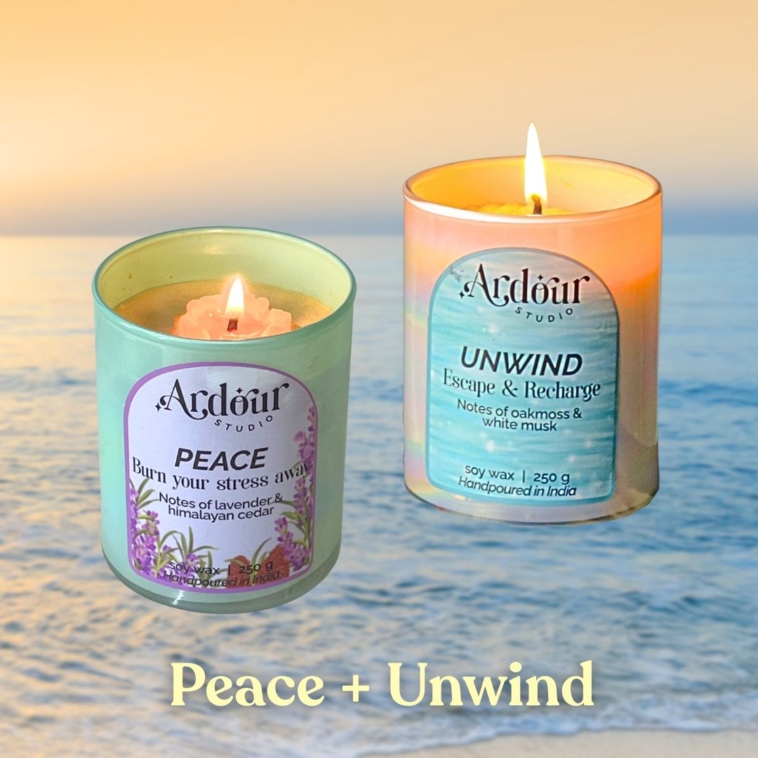Two scented candles labeled 'Peace' and 'Unwind' on a beach with ocean waves in the background.