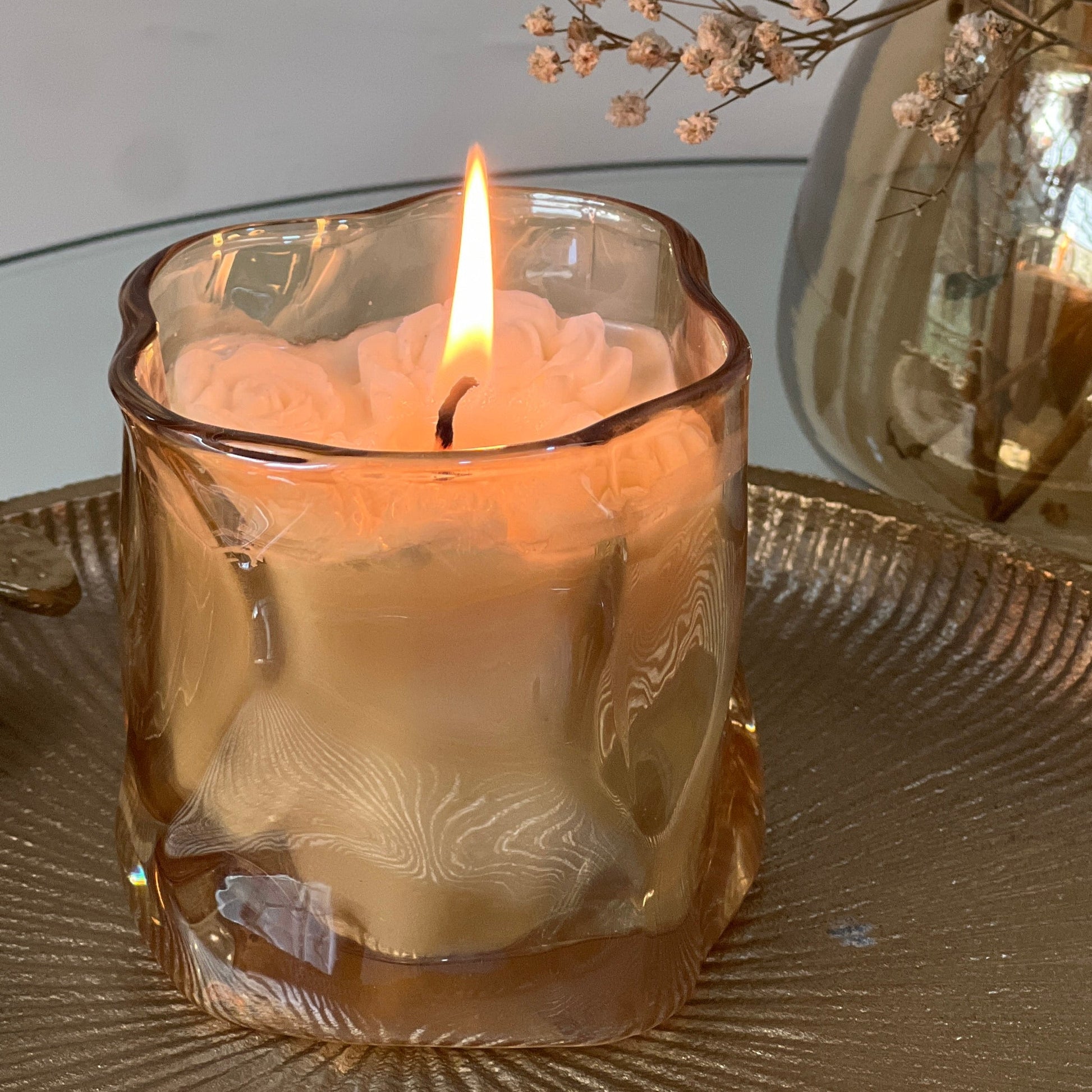 Jasmine scented Candle in a golden asymmetrical  glass holder with a blurred background