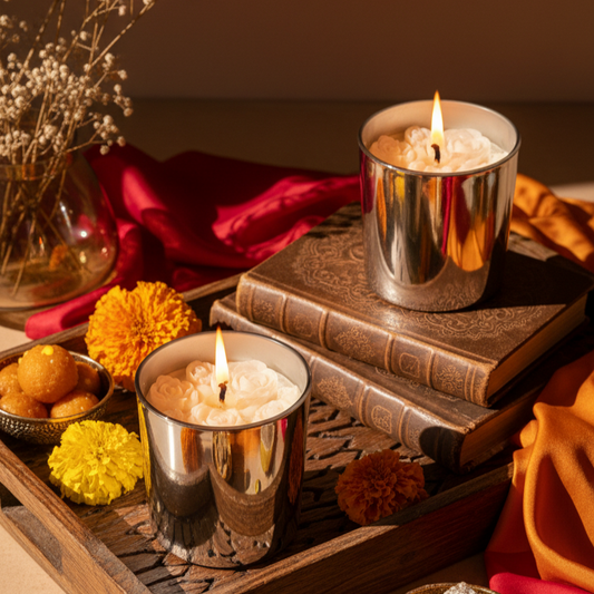 Candlelit scene with candles in metallic holders, books, and decorative items on a wooden tray.