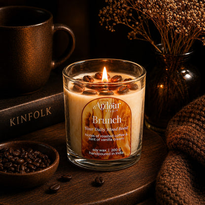 Candle labeled 'Brunch' with coffee beans and a cup in a warm setting