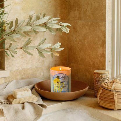 Candle in a wooden bowl on a bathroom counter with a plant and basket in the background