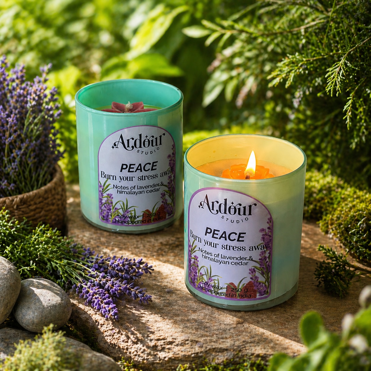 Two Ardour Studio 'Peace' candles on a wooden surface with lavender and greenery in the background.