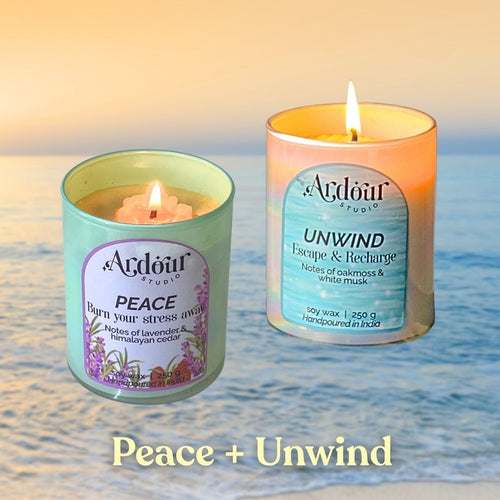 Two scented candles labeled 'Peace' and 'Unwind' on a beach with ocean waves in the background.