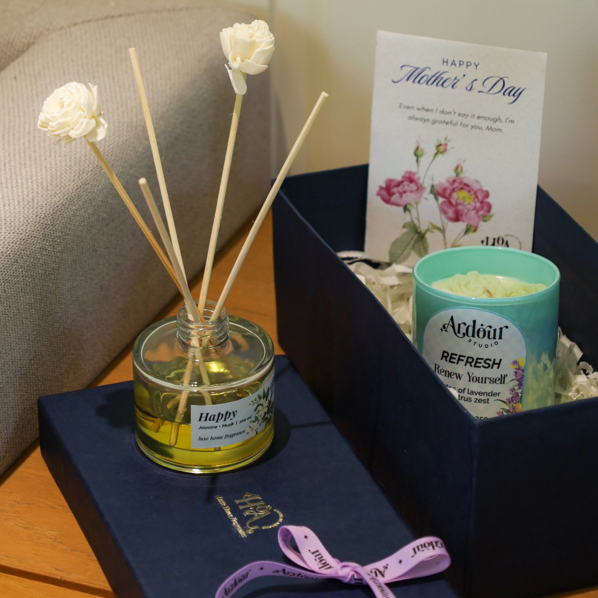 Gift set with diffuser, candle, and card on a wooden surface