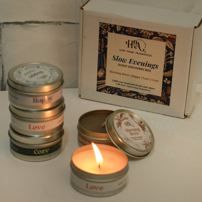 Stack of small candles with tins and a branded box on a tiled surface