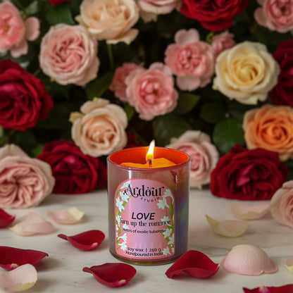 Love candle with flowers and petals on a marble surface