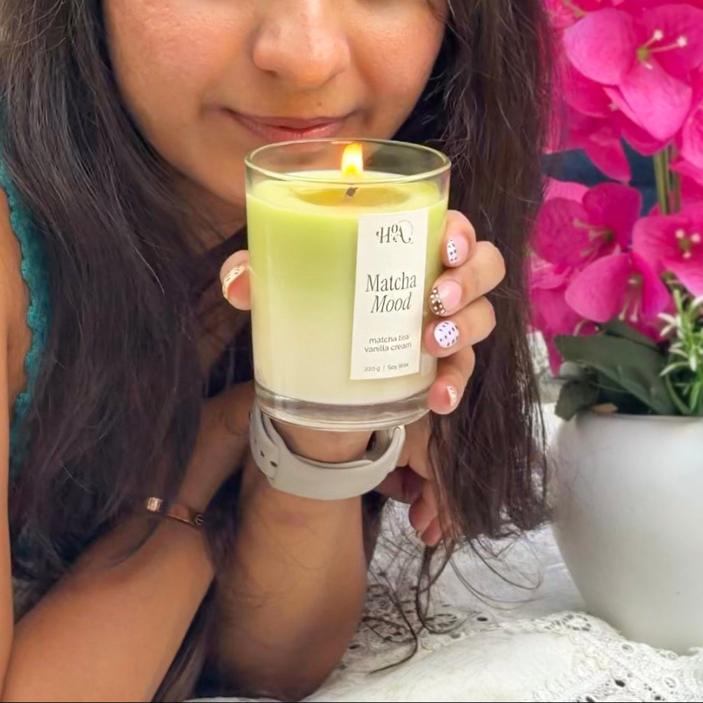 Woman holding a lit candle with a floral background