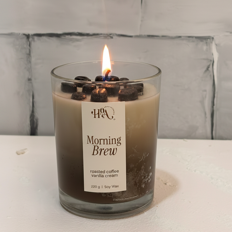 Candle labeled 'Morning Brew' with coffee beans on a white surface and light gray tiled wall background