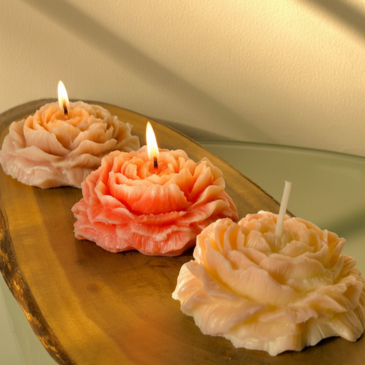 Three decorative candles on a wooden surface with a soft light background