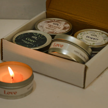 Set of small candles with 'Love' text in a box on a light surface.
