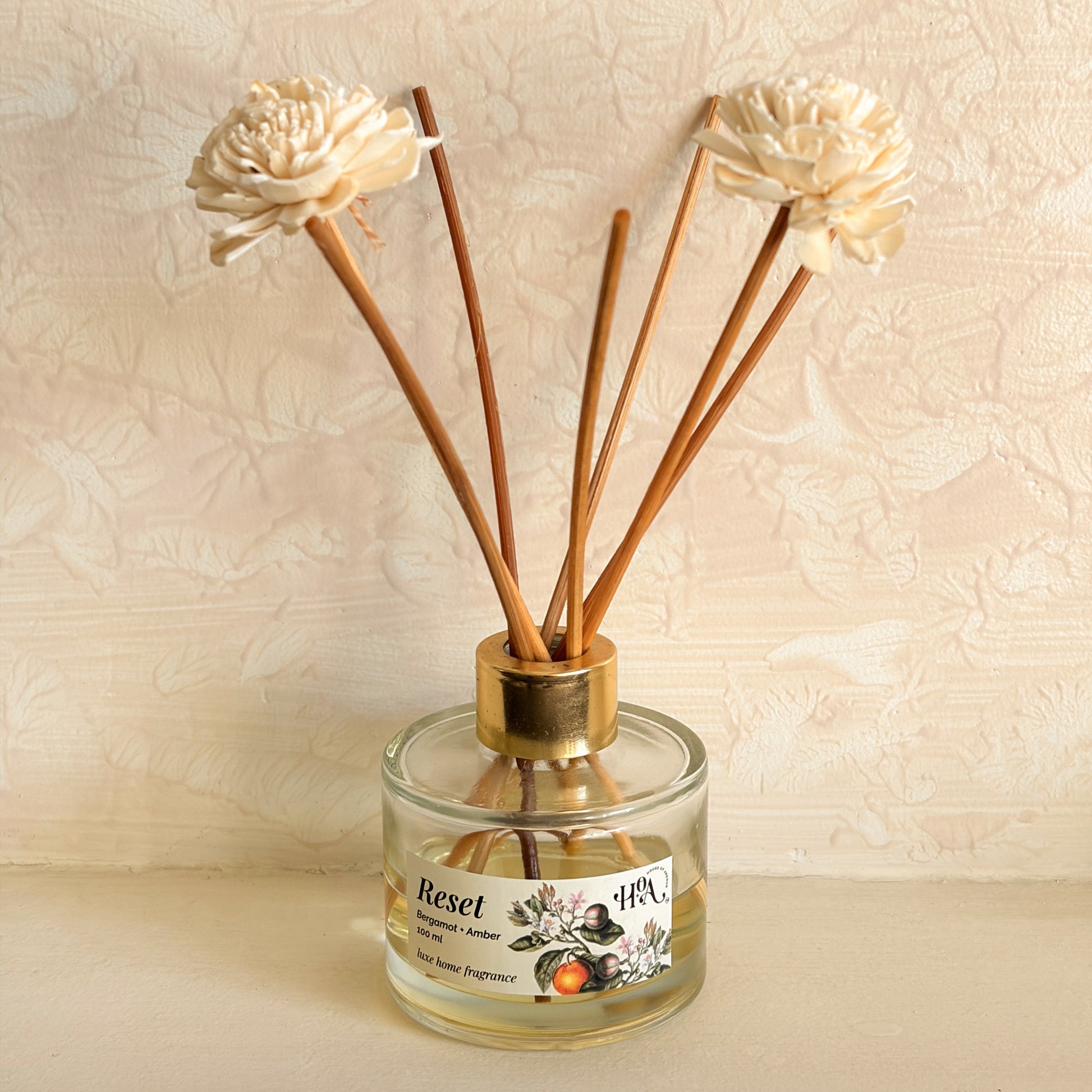 Reed diffuser with floral design on a beige background