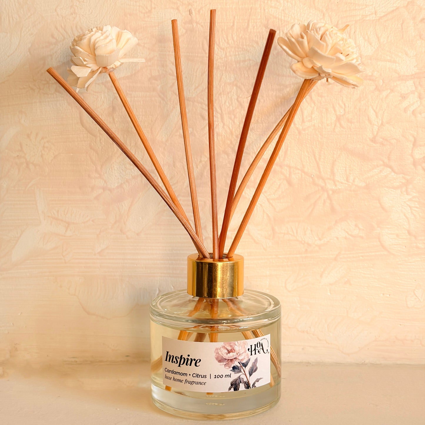 Reed diffuser with wooden sticks and flowers on a beige background