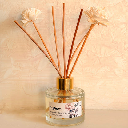 Reed diffuser with wooden sticks and flowers on a beige background