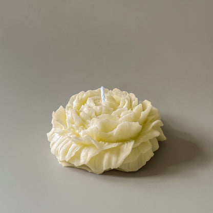 Floral-shaped candle on a plain background
