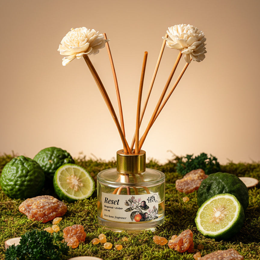 Reed diffuser with flowers and natural elements on a grassy surface