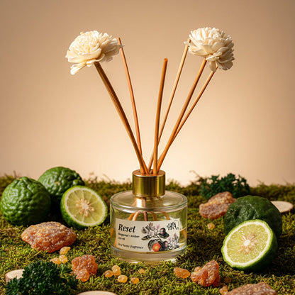 Reed diffuser with flowers and natural elements on a grassy surface